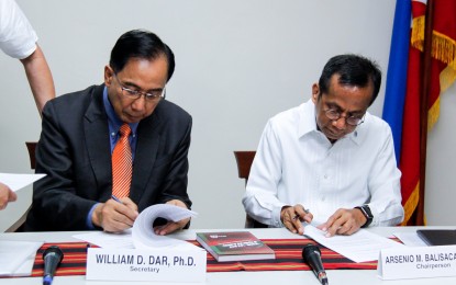 <p><strong>COMPETITION IN AGRICULTURAL MARKETS</strong>.  Agriculture Secretary William Dar (left) and Philippine Competition Commission Chair Arsenio Balisacan sign a memorandum of agreement (MOA) to strengthen coordination and mutual advisory assistance on competition concerns given the agriculture sector’s primary importance to consumer welfare. The MOA signing was held at the DA central office in Quezon City on Tuesday (Oct. 1, 2019). <em>(Photo courtesy of DA)</em></p>