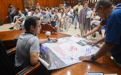 <p><strong>REVIEW</strong>. Manila City Mayor Francisco "Isko Moreno" Domagoso checks the map of government's infrastructure projects showing private properties that may be affected during a dialogue with the Sampaloc People's Alliance, Paco People's Alliance, Tondo People's Alliance, and Samahan ng mga Apektadong Pamilya sa Balic-Balic at the Manila City Hall on Tuesday (Oct. 1). <em>(Photo courtesy of Manila Public Information Office)</em></p>