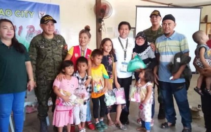 <p><strong>SPECIAL INTERVENTION.</strong> Col. Consolito Yecla, commander of Task Force Davao (2nd from left) and Commissioner Norman Baloro of the Office of the Presidential Commission for the Urban Poor (wearing white), pose with the Internally Displaced Persons from Marawi siege who were provided special intervention in Davao City on Wednesday (Oct. 2, 2019). The IDPs have completed the initial screening and social investigation by assessing their general health and well-being after staying in this city for more than two years after the liberation of Marawi from Islamic State-linked militants <em>(Contributed photo)</em></p>