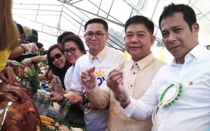 <p><strong>LECHON FEST.</strong> (From right to left) Bulacan Gov. Daniel R. Fernando, DILG Assistant Secretary for Peace and Order Manuel B. Felix, Pandi Mayor Rico Roque and Vice Mayor Lui Sebastian as they lead the lechon boodle fight at the Barangay San Roque covered court in Pandi, Bulacan on Tuesday (Oct. 8, 2019). The activity was held to show the public that pork and other meat products sold in the local markets are safe to eat and free of the Asian swine fever virus. <em>(PNA photo by Manny Balbin)</em></p>