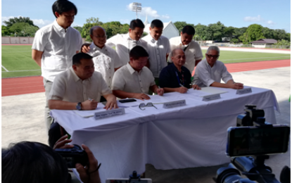 <p><strong>SEA GAMES HOST.</strong> Officials of Biñan City and 30th Southeast Asian Games Executive Committee forge the memorandum of agreement at the Biñan City Football Stadium in Laguna on Monday (Oct. 7, 2019). Biñan will host the women’s football and some men’s matches of the 30th Southeast Asian Games. (Seated from left) Vice Mayor Angelo Alonte, Mayor Walfredo Dimaguila Jr., SEA Games Executive Committee Director Tomas Carrasco Jr., and Metro Manila Venues Cluster chief Michael T. Verano signed the agreement. <em>(PNA photo by Saul E. Pa-a)</em></p>