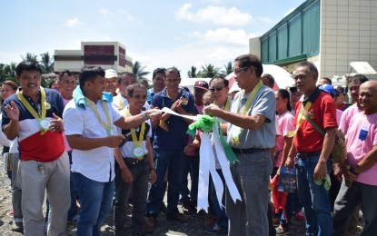 <p><strong>RICE PROCESSING COMPLEX.</strong> Mayor Ernesto Evangelista (holding the ribbon) leads the inauguration of the PHP5.9-million rice processing complex located in New Visayas village, Sto. Tomas, Davao del Norte, on Wednesday (October 9). The beneficiary of the rice processing complex is the Gravity Irrigators Service Association, Inc., a local farmers cooperative. <em>(Contributed photo)</em></p>