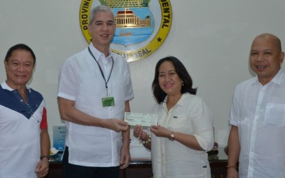<p><strong>CROP INSURANCE.</strong> Negros Occidental Governor Eugenio Jose Lacson (2nd from left) turns over the PHP4.92-million check to Philippine Crop Insurance Corp. Regional Manager Eva Laud during their meeting at the Provincial Capitol on Thursday (October 10, 2019). The amount is the provincial government’s additional allocation for farmers’ premiums. The event was witnessed by Jose Ma. Torres (right), head of PCIC-Negros Occidental, and Provincial Agriculturist Japhet Masculino (left). <em>(Photo courtesy of PIO Negros Occidental)</em></p>