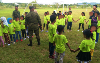 <p><strong>FUN-FILLED DAY.</strong> Soldiers teach Moro kids how to play soccer inside the compound of the Army’s 602nd Infantry Brigade in Carmen, North Cotabato on Friday (Oct. 11, 2019) as part of its pre-anniversary activities. A total of 32 kids, some of whom were children of former members of the Moro Islamic Liberation Front, were also treated to a mall tour and a party at a popular fast-food chain in Kidapawan City. <em>(Photo courtesy of 602nd IB)</em></p>