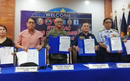 <p><strong>UNITE TO END INSURGENCY.</strong> Members of the Peace, Law Enforcement and Development Support (PLEDS) Cluster of the Regional Task Force to End the Local Communist Armed Conflict (RTF-ELCAC) in Western Visayas sign their Implementation Plan at Camp Delgado in Iloilo City on Saturday (Oct. 12, 2019). The plan contains the commitments forged by the cluster members to fight insurgency and gear towards attaining sustainable and lasting peace in the region. <em>(PNA photo by Gail Momblan)</em></p>