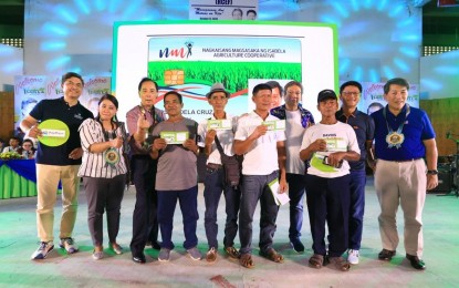 <p><strong>DBP, PAYMAYA TIE-UP.</strong>  Members of the NMI Agri Coop receive their ATM IDs during the launch of the Rice Competitiveness Enhancement Fund (RCEF) for Isabela Saturday (Oct. 12, 2019). Through the PayMaya powered ID cards, rice farmers will their receive payments for their produce from NMI Agri Coop, as well as disbursements from cash assistance from DBP-partner local governments and organizations. In photo are (from left) PayMaya Director and Head of Enterprise Business Mar Lazaro; NMI Agri Coop President Ana Cristina Siquian-Go; Agriculture Secretary William Dar; Isabela Governor Rodito Albano III (fourth from right); Isabela Vice Governor Faustino “Bojie” Dy III (second from right); DBP President and CEO Emmanuel Herbosa (rightmost); and rice farmers and NMI Agri Coop members who received their ATM ID Card. <em>(Photo courtesy of PayMaya)</em></p>
