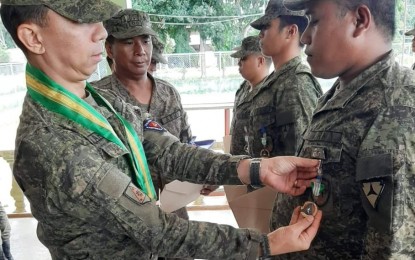 <p><strong>SOLDIERS AWARDED.</strong> Brig. Gen. Benedict Arevalo (left), commander of the 303rd Infantry Brigade of the Philippine Army, pins medals of citation to 29 soldiers of the 94th Infantry Battalion based in Negros Oriental in a ceremony on Wednesday (Oct. 16, 2019). The soldiers received the Military Commendation Medals for their efforts during the Oct. 3 clash with suspected New People's Army members in Barangay Bantolinao, Manjuyod, Negros Oriental. <em>(Photo courtesy of the Philippine Army)</em></p>