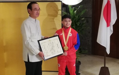 <p><strong>CHAMPION GYMNAST.</strong> Carlos Yulo receives a certificate of commendation from Japanese Ambassador Koji Haneda in Manila for his world gymnastics championships win and contribution to Philippine-Japanese friendship on Thursday (Oct. 17, 2019). Yulo trained under Japanese coach, Munehiro Kugimiya. <em>(PNA photo by Joyce Ann L. Rocamora)</em></p>