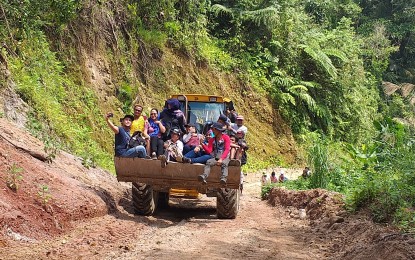 <p><strong>FAR-FLUNG VILLAGE.</strong> Provincial government workers ride a payloader heading for Kagbana village, one of the most remote villages in Leyte Island, some 40 km. from the town center of Burauen. The village has nearly 300 residents, including 50 Mamanwa tribe members. <em>(PNA photo by Sarwell Meniano)</em></p>