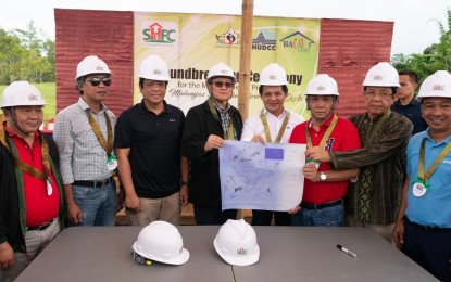 <p><strong>HOUSING FOR MARAWI.</strong> Task Force Bangon Marawi chairperson and Housing and Urban Development Coordinating Council Secretary Eduardo del Rosario (4th from left) and Marawi City Mayor Majul Gandamra (5th from left) present the blueprint of the housing project that will benefit 1,500 families displaced by the Marawi siege. The construction site of the housing units for 100 families from Barangay West Dulay broke ground on Thursday (Oct. 17, 2019) during the commemoration of the second anniversary of the capital’s liberation from Islamic State-inspired terrorists. <em>(Photo from PCOO)</em></p>