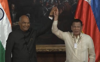 <p><strong>BOOSTING PH-INDIA TIES.</strong> President Rodrigo Duterte and Indian President Ram Nath Kovind raise each other's hands during their bilateral meeting at Malacañan Palace on Friday (Oct. 18, 2019). The two leaders also witnessed the exchange of four agreements that intend to boost relations between Manila and New Delhi. <em>(Screengrab from Presidential Communications Facebook page)</em></p>