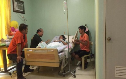 <p>Zhydee Cabañelez, a teacher at Dalit Elementary School in Sitio Dalit, Barangay Lumbayao in Valencia City, Bukidnon, gets a visit from a official of Department of Education in Northern Mindanao after she and her partner, Ramel, survived a shooting on Tuesday (Oct. 15).  Ramel escaped the attack unscathed. </p>