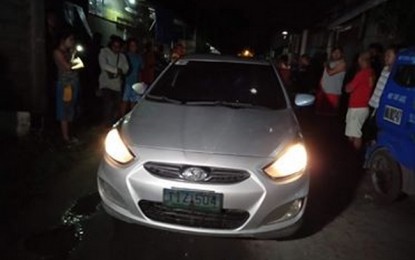 <p><strong>AMBUSH.</strong> Onlookers crowd the gray Honda sedan of Police MSgt. Emmanuel Coronado,  who was waylaid with his three children at the junction of Maria Theresa Subdivision and Yumang Street in Barangay San Isidro, General Santos City, past 9 p.m. Friday (Oct. 18, 2019). Coronado, a police intelligence officer, was killed while his children were wounded in the attack. <em>(PNA photo by Richelyn Gubalani)</em></p>