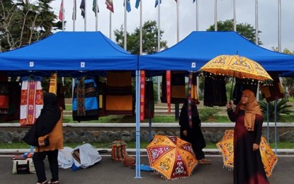<p><strong>BACK TO BUSINESS.</strong> A woman displays her Meranaw-designed umbrellas in one of the stalls in front of the Provincial Capitol of Lanao del Sur, in Marawi City, on Thursday (Oct. 17, 2019). Various livelihood cooperatives composed of internally-displaced persons showcased their products in a trade fair that coincides with the second anniversary of President Rodrigo Duterte's declaration of Marawi's liberation from terrorist influence, following a five-month siege by Islamic State-inspired militants in May 2017. <em>(PNA photo by Nef Luczon)</em></p>