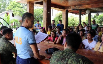 <p><strong>DIALOGUE.</strong> Maj. Antonio Benitez Jr. (standing), chief of Sagay City Police Station, along with officers of the Philippine Army’s 79IB, meets with the families of the “Sagay 9” victims in the northern Negros City on Sunday (Oct. 20, 2019). The dialogue was part of the activities that commemorated the first anniversary of the massacre that took place on Oct. 20, 2018. <em>(Photo courtesy of 79IB, Philippine Army)</em></p>