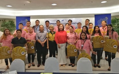 <p><strong>SEAL OF EXCELLENCE.</strong> The Department of Trade and Industry hands over the Bagwis Award (gold category) to 17 outlets of the convenience store chain, 7-Eleven, for having complied with government regulations and putting a premium on consumer welfare. DTI Assistant Secretary Anne Claire Cabochan (in red blouse) led the awarding on Wednesday (Oct. 23, 2019), together with DTI provincial director Nimfa Virtucio.<em> (PNA photo by Judy Flores Partlow)</em></p>