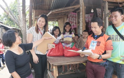<p><span lang="EN-US"><strong>RELIEF AID.</strong> Personnel of the Provincial Disaster Risk Reduction and Management Office of South Cotabato distribute food and cash assistance to one of the households affected by a mild tornado in Tupi town last Sunday. A total of 29 families from barangays Poblacion and Bunao were affected by the incident. <em>(Photo courtesy of the provincial government)</em></span></p>