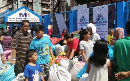 <p><strong>'KOLEK, KILO, KITA'.</strong> Residents fall in line waiting for their turn to weigh their plastic wastes at the launch of the 'Kolek, Kilo, Kita para Walastik na Maynila' on Saturday (Oct. 26, 2019). Under the program, residents will get PHP10 worth of homecare products from Unilever Philippines for every kilo of collected plastic wastes. <em>(PNA photo by Lade Kabagani)</em></p>
