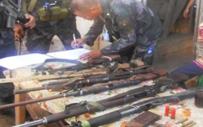 <p><strong>CONFISCATED.</strong> A police officer conducts an inventory of some of the recovered high-powered firearms during a series of raid on Friday (Oct. 25, 2019) in Sitio Datal Lutay, Barangay B’laan in Malungon, Sarangani province. The operation targeted members of an armed lawless group based in the area. <em>(Photo courtesy of the Police Regional Office-12)</em></p>