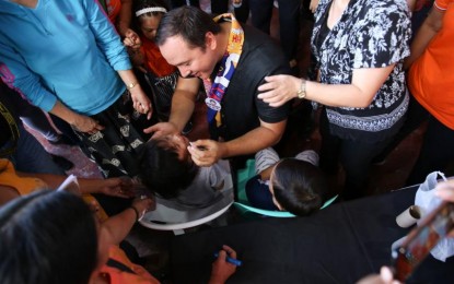 <p><strong>ANTI-POLIO VACCINATION</strong>. Taguig City Mayor Lino Cayetano administers an oral polio vaccine to a child during the recent Health department’s “Sabayang Patak Kontra Polio” campaign. Taguig successfully vaccinated 96,866 children, the highest in the National Capital Region.<em> (Photo courtesy of Taguig PIO)</em></p>