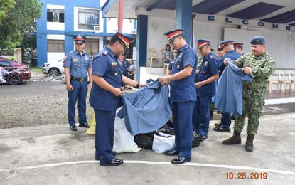 <p><strong>SNIPPING AWAY.</strong> Antique Provincial Police Office (ANTPPO) Director Col. Leo Irwin Agpangan (left) cuts into pieces an old police uniform confiscated during police inspection. The destruction of the old uniform was held right after the flag-raising ceremony at the provincial police headquarters on Monday (Oct. 28, 2019). <em>(Photo courtesy of ANTPPO)</em></p>