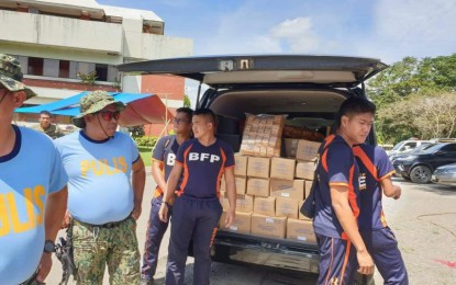 <p><strong>FOOD FOR QUAKE VICTIMS.</strong> Police officers and firefighters assist in the distribution of food packs from the Department of Science and Technology (DOST) for earthquake victims in Mindanao on Friday (Nov. 1, 2019). These packs include rice porridge, smoked fish rice meal, and BigMo (bigas-mongo) curls, all developed by the agency. <em>(Photo courtesy of DOST Secretary Fortunato dela Peña)</em></p>