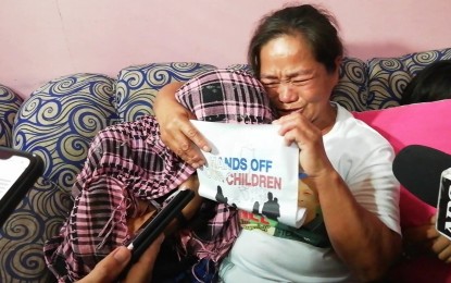 <p><strong>SAFE IN MOTHER'S ARMS.</strong> Nilda Villamonte of La Carlota City, Negros Occidental tightly embraces her 12-year-old daughter after they were reunited in Bacolod City on Saturday. The girl, whom she thought was just attending a dance practice for a cultural show, was among the 14 minors arrested by the authorities during a raid in the compound of progressive groups in Barangay Bata on Thursday afternoon.<em> (PNA photo by Nanette L. Guadalquiver)</em></p>