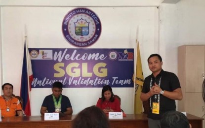 <p><strong>GOOD GOVERNANCE.</strong> Mayor Roland Boie Evardone (standing) is shown with the Seal of Good Local Governance (SGLG) national validation team during their visit to Arteche, Eastern Samar last August. The town is one of the 17 areas in Eastern Visayas which are qualified to receive the SGLG seal. <em>(Photo courtesy of the Arteche local government)</em></p>