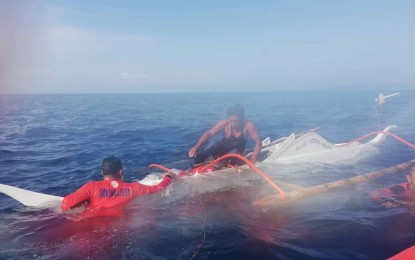 <p><strong>RESCUED FISHERMAN.</strong> Coast Guard personnel rescue a fisherman after his boat capsized off the coast of Abuyog, Leyte on Tuesday (Nov. 5, 2019). Authorities rescued him around 8 a.m. on Tuesday after hours of clinging to the capsized vessel.<em> (Photo courtesy of Philippine Coast Guard)</em></p>