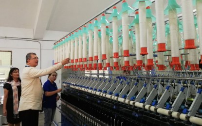 <p><strong>YARN PRODUCTION.</strong> Department of Science and Technology Secretary Fortunato de la Peña checks the ring frame, one of the machines at the Regional Yarn Production and Innovation Center unveiled on Wednesday (Nov. 6, 2019) at Iloilo Science and Technology University-Miagao campus. The center will enable the hablon-weaving town of Miagao to produce its own yarn from cotton and other raw materials grown from its soil. <em>(PNA photo by Gail Momblan)</em></p>