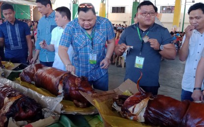 <p><strong>SAFE TO EAT PORK</strong>.  San Carlos City Mayor Julier Resuello and Vice Mayor Joseres Resuello (third and second from right respectively), together with the city councilors and city hall department heads, lead the feast showcasing lechon and other pork viands to show that pigs grown here and the pork meats being sold at the public markets are clean and safe from African swine fever. The 'Let's Pork Eat' event was spearheaded by the Meat Vendors Association and local high raisers.  <em>(Photo by Liwayway Yparraguirre)</em></p>