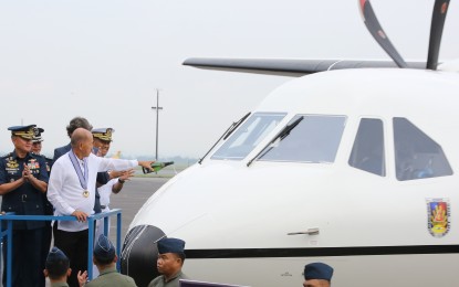 <p><strong>NEW C-295 AIRCRAFT.</strong> Defense Secretary Delfin Lorenzana pours champagne on the newly-acquired Airbus Defense and Space C-295M aircraft during the turnover ceremony at the Clark Air Base in Pampanga on Monday (Nov. 11, 2019). This is the Philippine Air Force's fourth C-295M aircraft which is expected to boost the service's tactical airlift requirement of transporting troops and equipment, as well as, to support humanitarian assistance and disaster relief operations. <em>(Photo courtesy of PAF Public Information Office)</em></p>