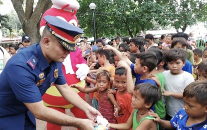 <p><strong>MOLDING BETTER KIDS</strong>. Talisay City Police Station chief, Maj. Gerard Ace Pelare, hands out burgers to children, who are beneficiaries of the Police and Partners Act of Kindness for the Children in Talisay (PACT) program, during the ceremonial feeding program in front of the police station on Wednesday (Nov. 13, 2019). Pelare said the PACT aims to help children of drug users through feeding and talks so that they will not go into the same illegal activities of their parents. <em>(PNA photo by Fe Marie Dumaboc)</em></p>