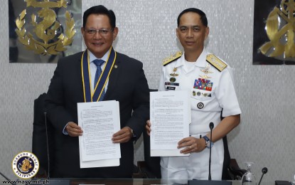 <p><strong>NAVY FUGA ISLAND DETACHMENT.</strong> Cagayan Economic Zone Authority (CEZA) chief executive officer, Secretary Raul Lambino (left), and Philippine Navy flag-officer-in-command, Vice Admiral Robert Empedrad (right), show a copy of the memorandum of agreement (MOA) signed between the two institutions on Wednesday (Nov. 13, 2019). The MOA formalizes the proposed Navy detachment which will be built in the CEZA-managed zone comprising the entire municipality of Santa Ana and the islands of Fuga, Barit and Mabbag, and Aparri in Cagayan.<em> (Photo courtesy of Naval Public Affairs Office)</em></p>