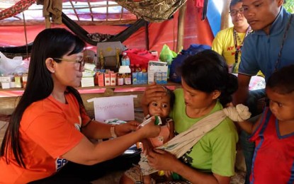 <p><strong>MEDICAL SERVICES.</strong> Barangay midwife Mary Jane Sabudan feeds a severely-malnourished baby in the isolated IP community of Sitio Tapayanon, Kapalong, Davao del Norte during the “whole-of-nation service convergence caravan” on Nov. 10-14, 2019. Some 700 residents of the IP community, which was once a lair of the New People’s Army, benefited from the multi-stakeholder outreach. <em>(Photo courtesy of Noel Baguio)</em></p>