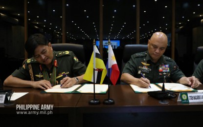 <p><strong>IMPROVING DEFENSE TIES.</strong> (Left) Royal Brunei Land Forces chief, Brig. Gen. Dato Seri Pahlawan Awang Khairul Hamed Bin Awang Haji Lampoh, and Philippine Army commander, Lt. Gen. Macairog Alberto, on Wednesday sign the terms of reference for the Memorandum of Understanding on Defense Cooperation between Philippines and Brunei which enhances military ties between the two nations. The two armies intend to conduct working group meetings, training courses, bilateral trainings, exchange of visits, subject matter expert exchanges, and intelligence exchanges.<em> (Photo courtesy of Philippine Army)</em></p>