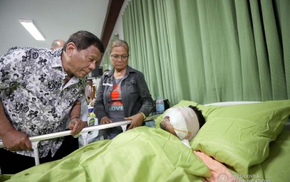 <p><strong>PRESIDENTIAL VISIT.</strong> President Rodrigo Duterte examines the injury of one of the soldiers wounded in a recent clash in Borongan City, Eastern Samar. The President conferred medals to critically wounded troops recuperating at the Divine Word Hospital in Tacloban City on Friday night (Nov. 15, 2019). <em>(Presidential photo)</em></p>