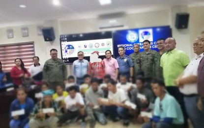 <p><strong>LIVELIHOOD ASSISTANCE.</strong> Seventeen former rebels receive their checks for them to start their livelihood during a Regional Task Force to End Local Communist Armed Conflict (RTF-ELCAC) event in Tagum City, Davao del Norte on Friday (Nov, 15, 2019). During the turnover, Department of Interior and Local Government assistant provincial director Janet Palmera scolded journalists who were covering the event. <em>(PNA photo by Che Palicte)</em></p>