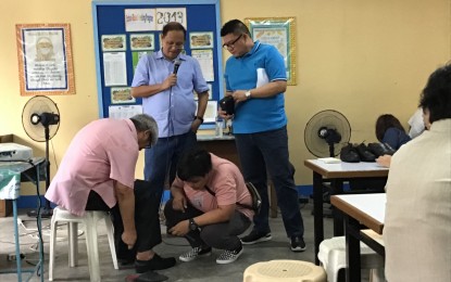 <p><strong>FREE SHOES FOR TEACHERS</strong>. Marikina Mayor Marcelino "Marcy" Teodoro looks on as a teacher tries a pair of shoes provided by the city government. He said a total of 2,681 teachers and 651 non-teaching personnel in Marikina will receive a pair good quality leather shoes.  <em>(Photo courtesy Marikina LGU)</em></p>