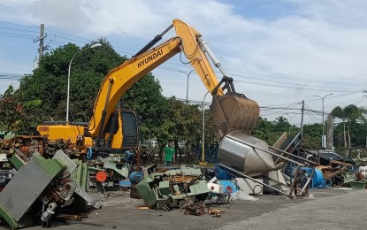 <p><strong>DESTROYED.</strong> A backhoe crushes smuggled cigarette-making machines and other equipment at the Port of Clark on Monday (Nov. 18, 2019). Customs officials seized the items last February 19 and forfeited last July 26 for violation of Section 1113 (f) and (l) of the Customs Modernization and Tariff Act.<em> (Photo courtesy of Port of Clark)</em></p>