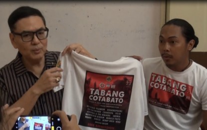 <p><strong>BENEFIT CONCERT</strong>. Former City Councilor Erik Miguel Espina, a Brigadier General in the Army Reserve, and concert organizer Yul Von Patrick Julia show to the media the sample t-shirt intended for the Tabang Cotabato benefit concert on Nov. 23, 2019, during a press conference at the Cebu City Hall on Wednesday (Nov. 20, 2019). Although the concert is for free, the audience is encouraged to bring relief goods that they can donate for the earthquake victims in Mindanao. <em>(PNA photo by Fe Marie Dumaboc)</em></p>