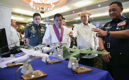 <p><strong>THANKFUL.</strong> President Rodrigo Roa Duterte gets a briefing from Defense Secretary Delfin Lorenzana during the 80th anniversary of the Department of National Defense at Camp General Emilio Aguinaldo in Quezon City on Wednesday (Nov. 20, 2019). The DND chief thanked the President for raising the salaries and pensions of all soldiers and veterans. <em>(Albert Alcain/Presidential Photo)</em></p>