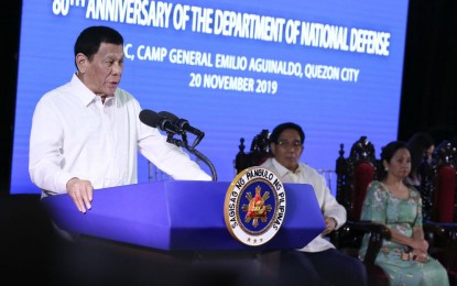 <p>President Rodrigo Roa Duterte delivers his speech during the 80th anniversary of the Department of National Defense at Camp General Emilio Aguinaldo in Quezon City on November 20, 2019. Duterte, in his speech, ordered the dismissal of 3 police officers accused of extorting money from bidders in the acquisition of 3,000 body-worn cameras. <em>(Presidential photo of Albert Alcain)</em></p>