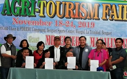 <p><strong>MOA SIGNING</strong>. SN Aboitiz Power-Benguet Representative Rose White (middle, seated), Governor Melchor Diclas and other officials of Benguet province pose for a photo opportunity following the signing of the memorandum of agreement for the development of a PPH12-million agri-innovation center and museum at Banangan, Sablan, Benguet on Nov. 18. The signing coincided with the opening of the agri-tourism fair event of the Adivay festival and 119th foundation anniversary of the province. <em>(PNA photo by Liza T. Agoot)</em></p>