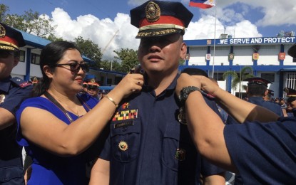 <p><strong>PROMOTED</strong>. Chief Master Sergeant Sarah Rosario dons the rank of Lieutenant Colonel on her husband, Allan Madrid Rosario, who was among the 941 police officers in Central Visayas who were promoted to the next higher rank, in a ceremony at Camp Sergio Osmeña Sr., Cebu City on Monday (Nov. 25, 2019). Of the 941 newly-promoted police officers, 553 are from Cebu, 188 from Bohol, 172 from Negros Oriental and 28 from Siquijor. <em>(PNA photo by Sheriza Mae Uy)</em></p>