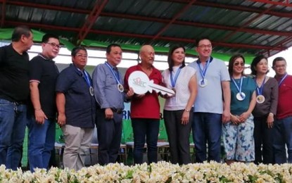 <p><strong>NEW HOMES.</strong> Ciudad de Strike 2 Home Owners Association Inc (HOAI) President Florencio Parader (5th from left) receive the ceremonial key from Social Housing Finance Corp (SHFC) President Atty. Arnolfo Ricardo Cabling (4th from left) and Bacoor city officials, mayor Lani Mercado Revilla (5th from right) and Cavite 2nd district representative Strike Revilla (4th from right) after the ceremonial turnover of housing units at Ciudad de Strike 2, Bayanan, Molino 1 Bacoor City on Saturday, (Nov. 23, 2019). Parader is representing some 1,400 families who used to live in danger zones in Las Piñas, Parañaque cities, are now benefiting from this partnership between the SHFC and the city government of Bacoor.<em> (PNA photo by Gladys S. Pino)</em></p>