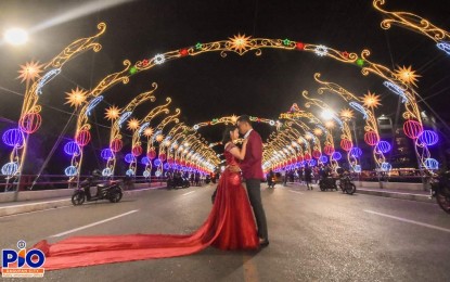 <p><strong>DAGUPAN LIGHTS</strong>. A couple chooses their pre-nuptial photos to be taken at the lighted Quintos bridge at Dagupan City. Aside from the Quintos bridge, the light tunnel and the giant wishing Christmas tree at the city plaza were also favorites of residents and tourists alike. <em>(Photo courtesy of Dagupan Public Information Office)</em></p>