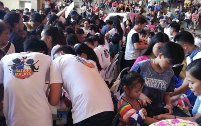 <p><strong>PROJECT ANGEL TREE</strong>. Personnel from the Department of Labor and Employment (DOLE-7) in Central Visayas and the Mandaue City government, along with volunteers from the private sector, distribute bags with school supplies, food and toys to around 900 children during the "Project Angel Tree" event in Mandaue City on Monday (Nov. 25, 2019). DOLE-7 Tri-City Field Office chief Emmanuel Ferrer said the program aims to improve the economic and social conditions of children and their families and increase the number of allies and advocates of child labor prevention and elimination.<em> (PNA photo by Fe Marie Dumaboc)</em></p>