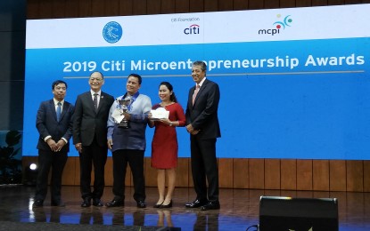 <p><strong>MICROENTREPRENEURSHIP AWARD</strong>. Citi Microentrepreneurship Awards (CMA) national winner Eduardo Azores (center), poses with Microfinance Council of the Philippines chair Eduardo Jimenez (left), BSP Governor Benjamin Diokno (second from left), and Rizal Microbank branch head Vivian Quenequez (right), during the awarding ceremony held at the BSP central office in Manila on Tuesday (Nov. 26, 2019). CMA honors entrepreneurs that showcased the power of microfinance as a poverty alleviation tool. (<em>PNA photo by Cristina Arayata</em>) </p>