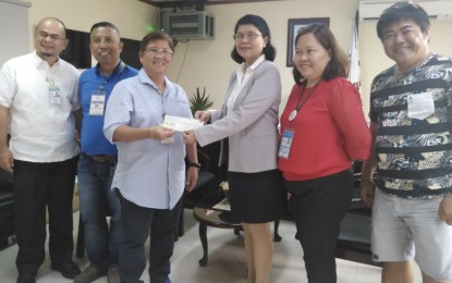 <p><strong>LIVELIHOOD ASSISTANCE</strong>. Poblacion Pardo, Cebu City Barangay official Manolita Abarquez (third from left) receives from Department of Labor and Employment (DOLE-7) Regional Director Salome Siaton a check amounting to PHP938,536 intended for 52 ambulant vendors who are beneficiaries of the DOLE Integrated Livelihood and Emergency Employment Program (DILEEP) in Central Visayas. Siaton said each vendor beneficiary can avail of the maximum grant amount of PHP20,000 to finance their small businesses under the Negosyo sa Kariton (Nego-Kart) concept. <em>(PNA photo courtesy of DOLE-7)</em></p>